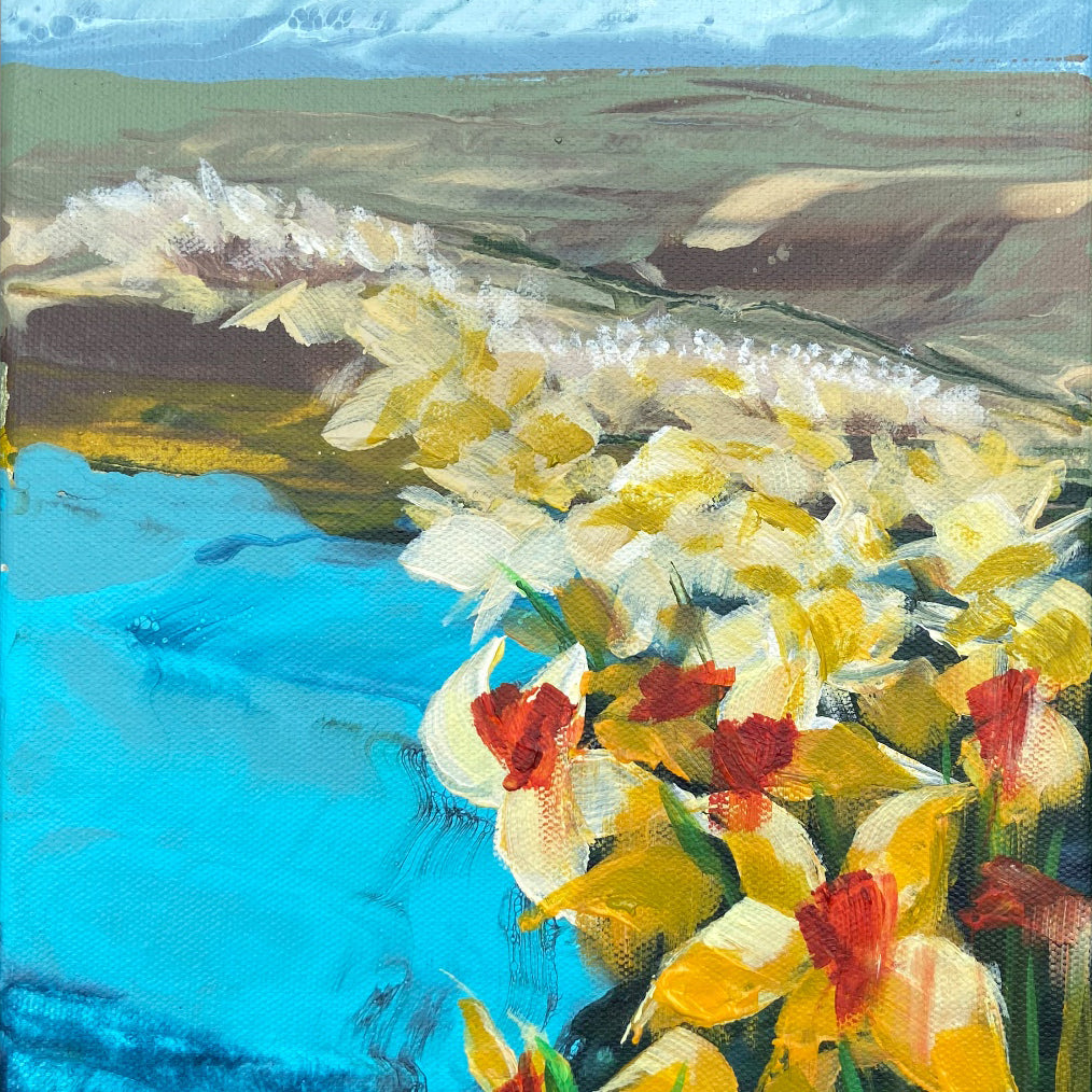 Painting of yellow and red flowers by a body of water with green hills in the background